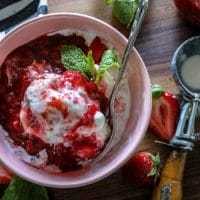 A plate of food on a wooden table, with Strawberry sauce