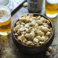 Smoked Marcona almonds in a bowl on tray with beer