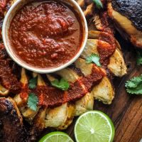 Grilled Spatchcock Chicken Tinga sliced on a cutting board