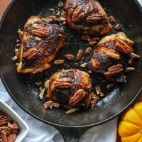 Grilled Crispy Maple Pecan BBQ Chicken Thighs in a skillet