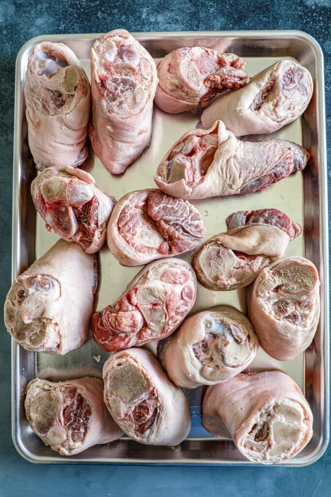 Raw pork hocks on a baking sheet